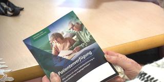 Eine Frau hält eine Patientenverfügung Broschüre in den Händen (Foto: SR)