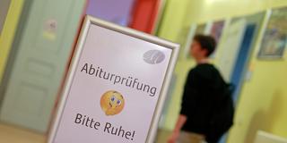 Ein Hinweisschild mit der Aufschrift «Abiturprüfung Bitte Ruhe» steht im Schulgebäude (Foto: picture alliance/dpa | Matthias Bein)