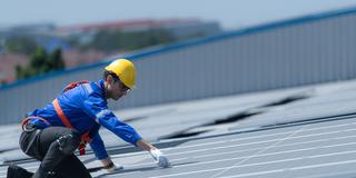 Ein Facharbeiter bei der Montage von Solarpanelen auf einem Dach. (Foto: picture alliance / Zoonar | Sunan Wongsa-nga)