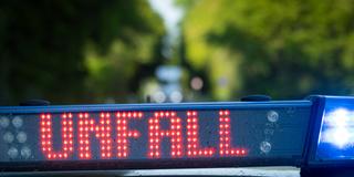 Ein Streifenwagen der Polizei steht mit Blaulicht und dem Schriftzug "Unfall" auf der Straße. (Foto: picture alliance /fotostand / Gelhot)