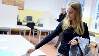 Eine junge Wählerin wirft ihren Stimmzettel in die Wahlurne (Foto: picture alliance / dpa | Britta Pedersen)