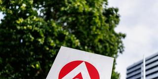 Das Logo der Agentur für Arbeit steht vor einem Gebäude. (Foto: picture alliance / dpa | Matthias Balk)