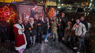 Das Team vom Architektenbüro in Eppelborn steht gemeinsam mit dem UNSERDING Team vor'm Weihnachtsmobil mit Glühwein. (Foto: UNSERDING)