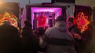 Menschen stehen vorm UNSERDING-Weihnachtsmobil und holen sich Getränke. (Foto: UNSERDING)