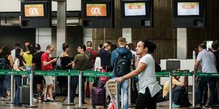 Ein junger Mensch schiebt einen Gepäckwagen am Flughafen. (Foto: IMAGO / Depositphotos)
