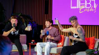 Zwei Männer und eine Frau sitzen nebeneinander und halten Gläser nach oben um sich zuzuprosten  (Foto: Liebt Euch Podcast)