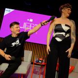 Ein Mann sitzt, eine Frau steht daneben. Er hält in ihre Richtung ein Mikrofon. (Foto: Liebt Euch Podcast)