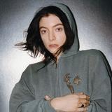 Lorde trägt eine graue Kapuzenweste und schaut in die Kamera. (Foto: Lorde (Pressefotos))
