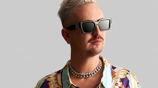 Robin Schulz Haare sind kurz und blond gefärbt, er trägt eine Sonnenbrille und ein kurzes Hemd. Er steht vor grauem Hintergrund und schaut mit neutralem Gesichtsausdruck zur Seite. (Foto: SR)