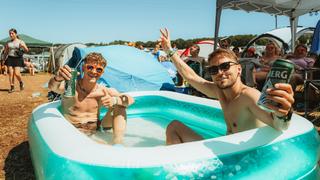 Zwei Festivalbesucher sitzen auf dem Campingplatz in einem Pool. (Foto: MxM Photo)
