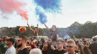 Zwei Menshen halten bunte rauchende Fackeln in den Himmel (Foto: MxM Photo)