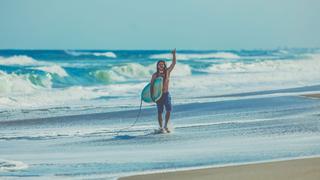 Ein Surfer läuft am Meer entlang (Foto: pixabay.com/StockSnap)