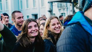 Zwei junge Frauen stehen in der Menschenmenge und lachen in die Kamera. (Foto: UNSERDING)