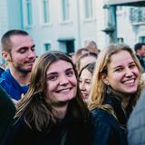 Zwei junge Frauen stehen in der Menschenmenge und lachen in die Kamera. (Foto: UNSERDING)